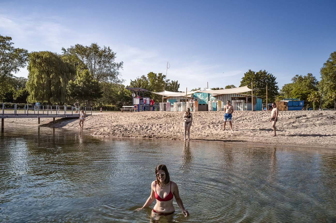 Frau im Wasser mit Leuten und Strand im Hintergrund