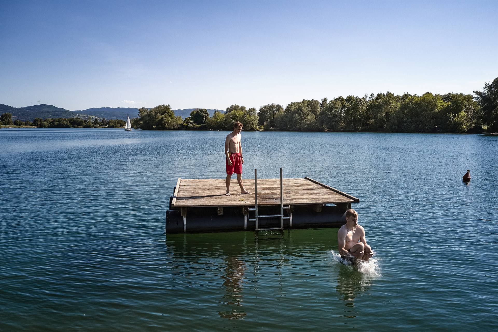 Mann steht auf Holzinsel im Wasser